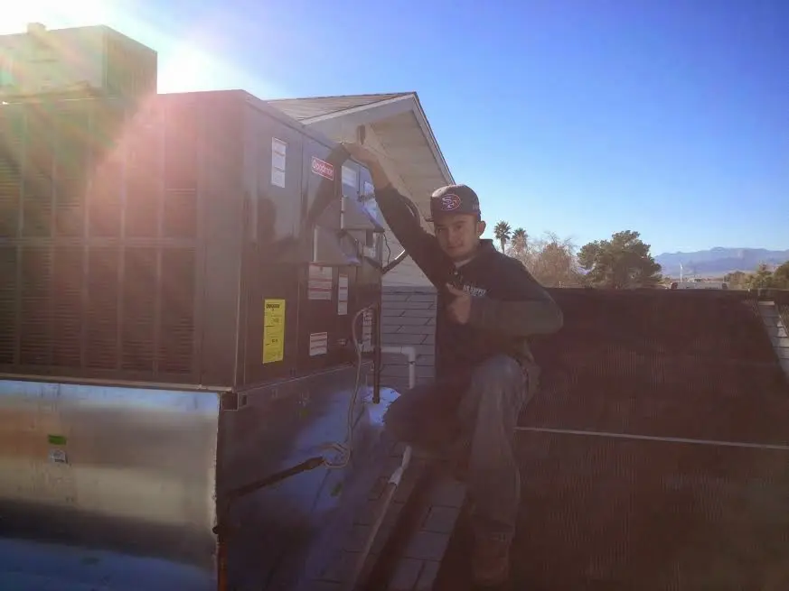 HVAC technician performing Heat Pump Repair on a rooftop unit in Lawrenceburg